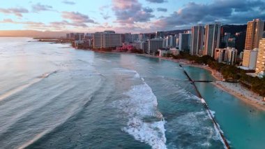 Pasifik Okyanusu 'nun su üzerinde uçmak kıyıya dalgalar göndermek. Gün batımında Waikiki, Honolulu, ABD 'nin çarpıcı manzarası.