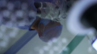 Erkek doktor yuvarlak lambanın yüzeyine yansıyor. Ameliyat odasındaki aydınlatmayı kapattım. Kapat..