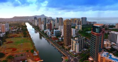 Gün batımında Honolulu 'daki Ala Wai Kanalı boyunca birçok araba hareket ediyor. Arkaplanda Diamond Head Krateri 'nin silueti. Hava görünümü.