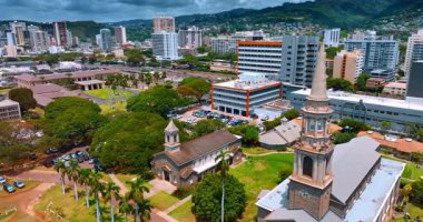 Güneşli bir günde resimli canlı bir şehir manzarası. Arkasında dağlar olan yeşil bir şehir. Honolulu, Hawaii, ABD. Hava görünümü.