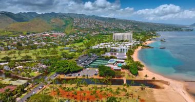 Pasifik Okyanusu kıyısında alçak katlı evler ve palmiye ağaçları var. Golf sahası sahil boyunca uzanıyor. Honolulu, Hawaii, ABD. Üst görünüm.