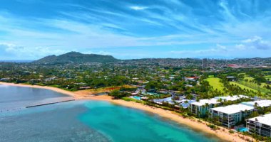Resimli sahile yaklaşan su manzarasının üzerindeki görüntüler. Hawaii 'nin yeşil yerleşim alanı, Hawaii, ABD. Diamond Head Krateri arka planda. Hava görünümü.