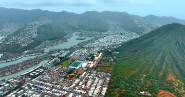 Dağlar ve yamaçlar arasında vadi boyunca yayılmış yoğun özel evler. Honolulu, Hawaii, ABD manzaralı. Hava perspektifi.