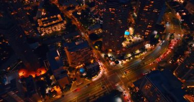 Arabalar gece vakti iyi aydınlatılmış Honolulu, Hawaii, ABD sokaklarında hareket ederler. İnsansız hava aracı görüntüleri güzel şehir manzarası üzerinde.