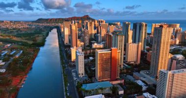 Waikiki tatil köyündeki yüksek binaları kaplayan güzel, yumuşak bir ışık. Diamond Head Carter, arka planda güneşin batışının ışığında. Honolulu, Hawaii, ABD 'de hava manzarası.