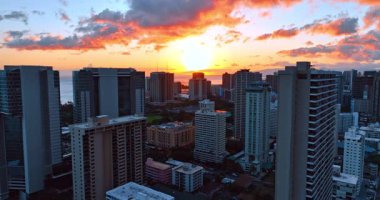 Modern Honolulu, Hawaii, ABD 'de alacakaranlık zamanı. Renkli bulutlarla sersemletici gökyüzü ve arka planda batan güneş.