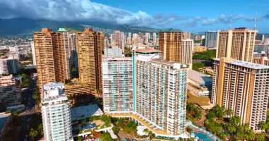 Honolulu, Hawaii, ABD 'nin mimarisi parlak güneşle aydınlandı. Dağların üzerinde büyük beyaz bulutlar toplandı. Hava görünümü.
