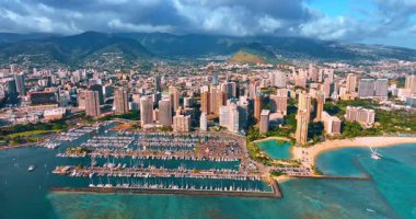 Waikiki, Honolulu, Hawaii, ABD kıyı şeridindeki yat kulübü. Arka planda dramatik bulutlarla kaplı yeşil dağlar. Hava görünümü.
