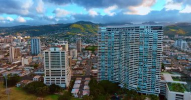 Honolulu şehrindeki çok katlı konut binasında yükseliyor. Arkaplanda resim gibi yeşil dağlar.
