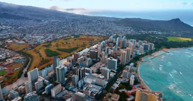 Waikiki bölgesindeki Honolulu 'nun yüksek binaların üzerinde uçuyor. Gün batımında şehre hava perspektifi. Arkaplanda Diamond Head Krateri.