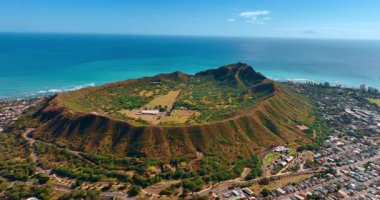 Birden fazla evle çevrili Diamond Head Krateri 'ne yaklaşıyoruz. Pasifik Okyanusu 'nun gök mavisi su manzarası. Hava görünümü.