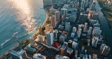 Waikiki Resort, Honolulu, Hawaii, ABD 'deki binaların çatısından. Gün batımında dalgalar sahile vurur. Hava görünümü.