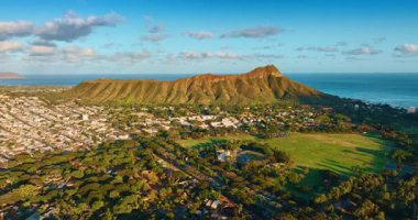 Diamond Head Krateri 'nin eteğindeki yeşil yerleşim bölgesi. Batan güneşin ışığında Honolulu 'nun ünlü simgesi. Hava görünümü.