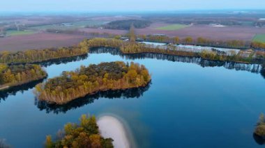 Hollanda havacılık manzarası. Hollanda 'daki gür ağaçlar ve canlı sonbahar renklerinin çerçevelediği dolambaçlı bir su yolunun nefes kesici görüntüsü..