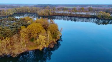 Hollanda su yollarını araştırıyorum. Hollanda 'da sonbahar boyunca altın ağaçlarla çevrili sakin su yollarının çarpıcı manzarası..