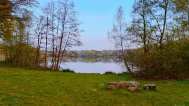 Hollanda 'daki yemyeşil göl. Hollanda 'nın alacakaranlığı sırasında sakin sularda ağaçlar ve gökyüzü yansıtılarak doğanın güzelliği gözler önüne seriliyor..
