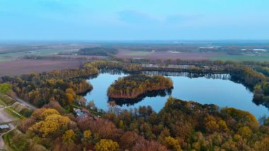 Serene Dutch manzara havası. Hollanda 'da yemyeşil sakin bir gölü çevreleyen yemyeşil, alacakaranlıkta Avrupa' nın büyüleyici güzelliğini gözler önüne seriyor..