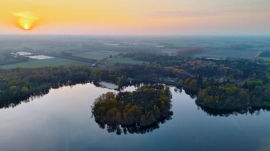 Hollanda günbatımı hava manzarası. Hollanda 'nın huzurlu kırsal kesiminde hava manzarası, sergilenen ağaçlar, su ve ılık renkler serpiştiren sakin bir günbatımı..