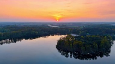 Hollanda 'da Lakeside' da gün batımı. Hollanda 'daki yemyeşil yemyeşil göllerle çevrili sakin göllere yansıyan canlı bir günbatımı görüntüler..