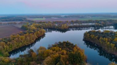 Hollanda sonbahar manzarası. Hava perspektifi Hollanda 'daki sakin suları çevreleyen ağaçların canlı sonbahar renklerini gözler önüne seriyor.