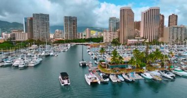 Turist teknesi birden fazla yat boyunca rıhtımlara taşınıyor. Waikiki, Honolulu, Hawaii 'nin modern mimarisi.