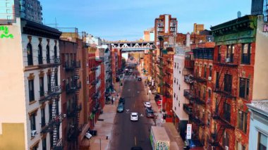 New York 'ta evleri olan bir cadde. Balkonlu ve merdivenli binalar boyunca insansız hava aracı görüntüleri..