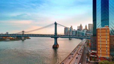 East River 'ın kıyısında yoğun otoyollar var. Gün batımında Manhattan Köprüsü ve Brooklyn Köprüsü 'nde hava perspektifi.