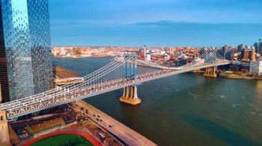 Parlak güneş ışığında güzel Manhattan Köprüsü manzarası. Doğu Nehri rıhtımında yükselen İHA New York 'un manzarasını gözler önüne seriyor..