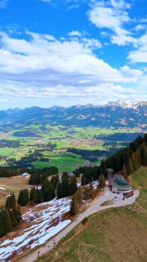 Bölgeyi kaplayan karla kaplı engin bir dağ manzarası. Funicular yolu dağın tepesinde. Almanya, Bavyera doğası manzarası. Dikey video.