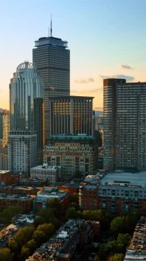 Boston, Massachusetts, ABD 'deki güzel yüksek binalar. Düşük katlı evlerin üzerinden uçan İHA görüntüleri gökdelenlere yaklaşıyor.