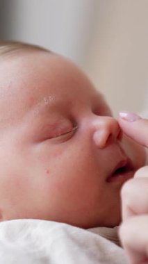 Kafkasyalı yeni doğan çok sıkı uyuyor. Anne çocuğun burnuna dokunuyor ama bebek uyanmıyor. Kapat.. dikey video