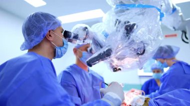 Mikroskoba bakan beyin cerrahları ameliyat yapıyor. Doktora ameliyat yerine şırıngadan ilaç doldurmasında yardım ediyorum..