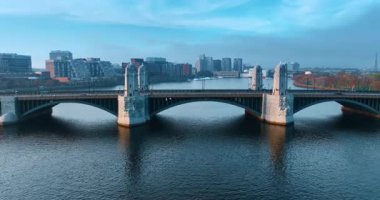 Boston, Massachusetts, ABD 'deki Harvard Köprüsü' nün kemerleri ve kuleleri. Su yüzeyinden yükselen İHA şehrin ufuk çizgisini gösteriyor..