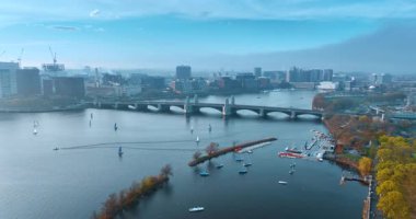 Birçok robot sonbahar günü Boston 'da Charles nehrinin kıyısına yelken açar. Nehir boyunca Harvard Köprüsü 'nden bir sürü araba geçiyor. Hava görünümü.