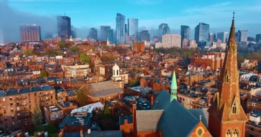 Boston 'un parlak mimarisinin üzerinde uçmak. Turuncu cepheli birçok eski tarz binaları olan bir bölge. Şehir merkezi sisle kaplı. Hava perspektifi.