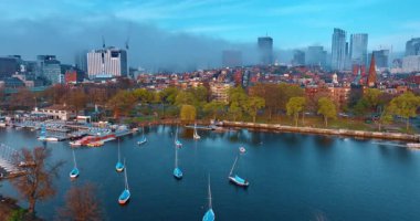 Charles Nehri 'nin suları. Çapada birkaç tekne var. Rıhtımdaki yollarda birden fazla araba hareket ediyor. Yüksek binalar sisle kaplıdır..