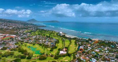 Honolulu, Oahu, Hawaii, ABD 'nin güzel manzarası. Golf sahasının üstündeki insansız hava aracı Pasifik Okyanusu 'nun turkuaz su yüzeyine yaklaşıyor..