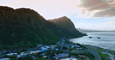 Güneş kayaların arkasında saklanıyor. Yerleşim alanı Pasifik Okyanusu kıyısındaki dağ kayalığındadır. Hawaii, ABD.