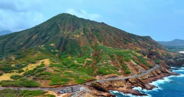 Kayanın ayağının yanından geçen otobanın çarpıcı manzarası. Su yüzeyinden Diamond Head Krateri. Honolulu, Hawaii, ABD.