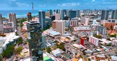 Aynalı cam gökdelenler modern şehir manzarası üzerinde yükseliyor. Sıcak güneşli bir günde Honolulu, Hawaii, ABD 'de insansız hava aracı görüntüleri.
