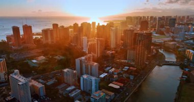 Batan güneşin turuncu ışığı Waikiki manzarasını kaplar. Güzel günbatımında Honolulu 'ya hava perspektifi.