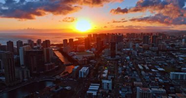 Pasifik Okyanusu 'nun su manzarası üzerinde inanılmaz turuncu güneş çemberi. Akşam üstü Honolulu şehir üzerinde insansız hava aracı uçuşu.