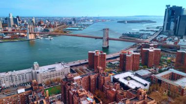 Doğu Nehri 'nin rıhtımına yaklaşıyoruz tuğla binaların üstünden. Brooklyn Köprüsü 'ne ve şehrin karşı kıyısına hava perspektifi.