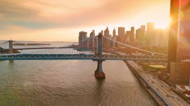 Turuncu ışık ABD 'nin New York manzarasını büyülüyor. Manhattan ve Brooklyn Köprüleri 'nin manzarası. İnsansız hava aracı görüntüleri.