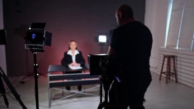 Kameraman kameranın arkasındaki yerinden ayrılır ve masada oturan bir bayana yaklaşır. Fotoğrafçı daha iyi bakmak için masadaki nesneleri tamir eder. Günlük konsepti.