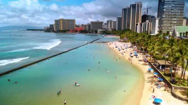 Temiz turkuaz suyu olan lüks kumlu bir sahil. İnsanlar Waikiki, Hawaii, ABD 'de Pasifik Okyanusu kıyısında dinleniyor. Hava görünümü.