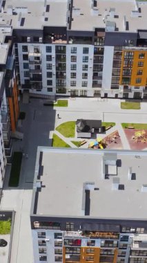 Konut kompleksinin modern binası. Şehirdeki apartman blokları üzerinde hava aracı görüntüsü. Dikey video