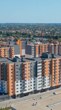 Çok katlı dairenin dışı. Yüksek apartmanlı şehir yerleşim alanının havadan görüntüsü. Dikey video