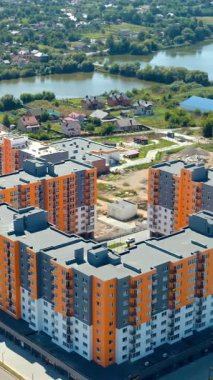 Şehirdeki modern şehir apartmanı. Yeni inşa edilmiş modern apartman cephesinin havadan görünüşü. Dikey video