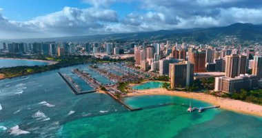 Pasifik Okyanusu 'nun turkuaz su manzarasının üzerinden büyük yat kulübüne doğru uçuyor. Bulutların altındaki Honolulu, Hawaii, ABD manzarasına hava perspektifi.